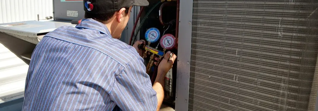 HVAC technician servicing a condenser unit in Dawsonville